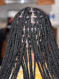 the back of a woman with braids in her hair